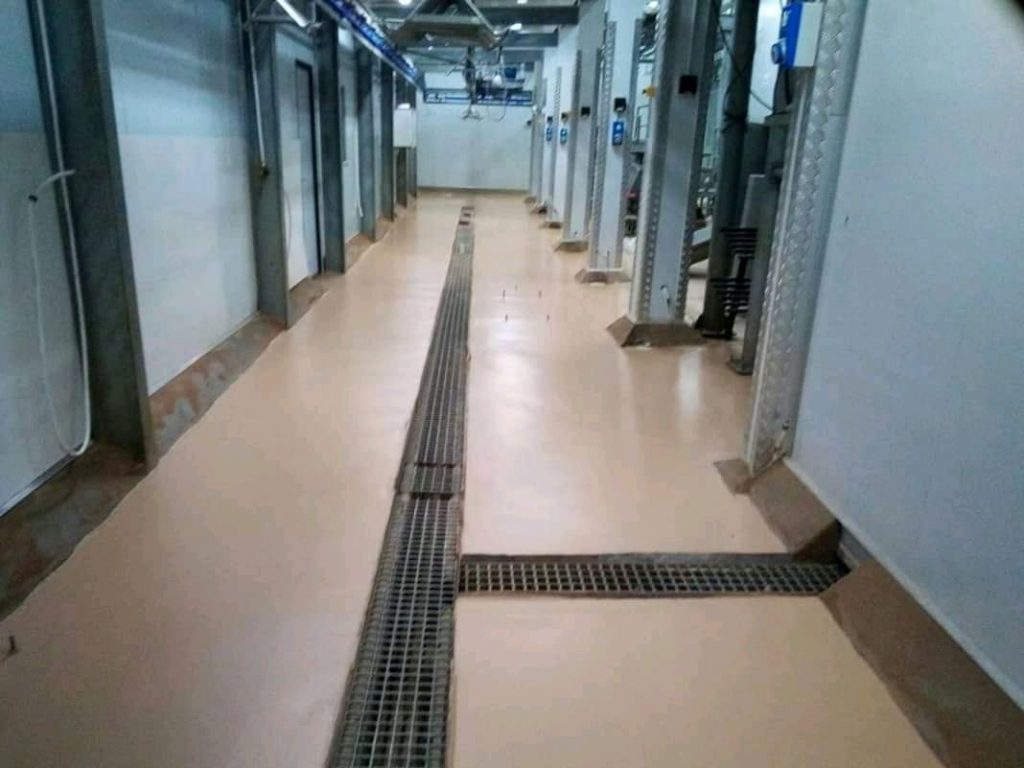 Epoxy floor coating in a commercial corridor with drainage channel