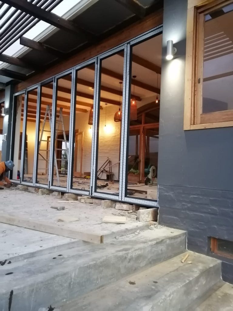 Aluminium folding glass doors along a covered patio